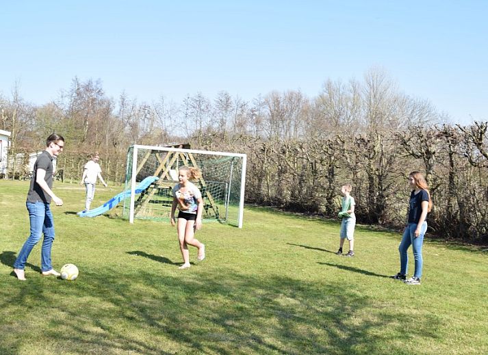 Kinderen springen op trampoline in de tuin van De Wulp, vakantiehuis in Burgh-Haamstede, Zeeland.
