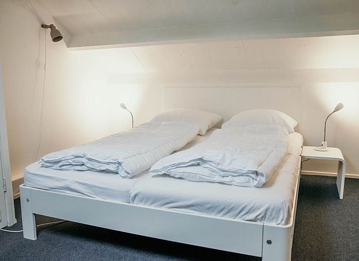 Sitzecke im Familienhaus Duinrand, Burgh-Haamstede, mit bequemen Stuehlen und einem Fernseher.