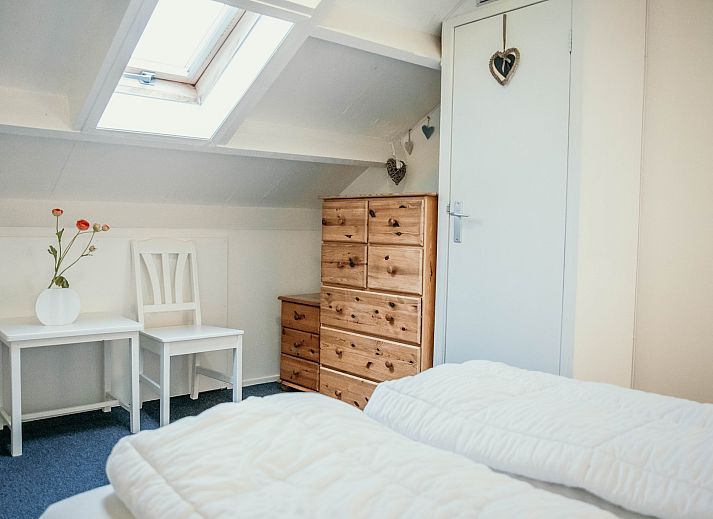 Sitzecke im Familienhaus Duinrand, Burgh-Haamstede, mit bequemen Stuehlen und einem Fernseher.