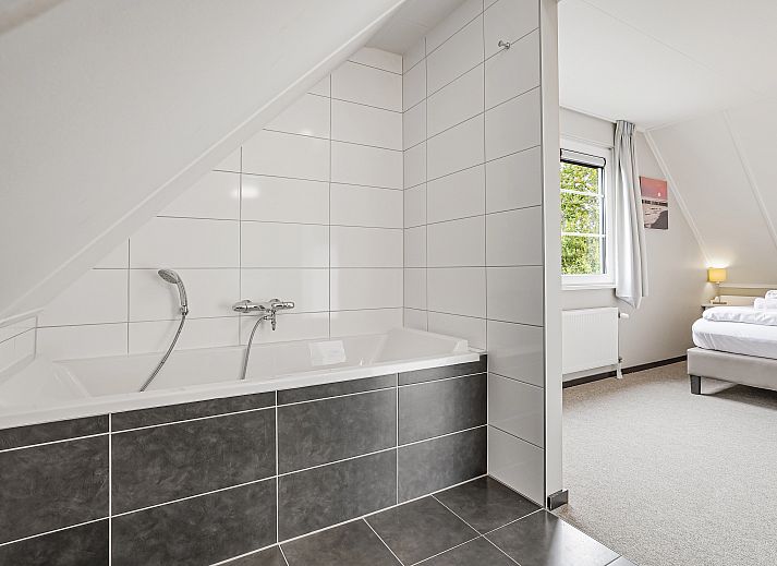 Gemuetliches Wohnzimmer im Resort Haamstede 6-Personen-Bungalow 6D, Burgh-Haamstede, mit grossem Sofa und TV.