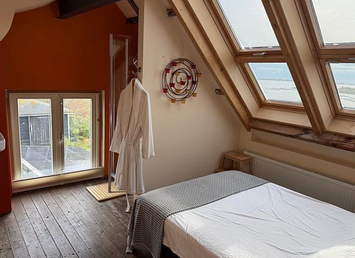 Sonniger Aussenbereich mit bunten Sitzgelegenheiten im Huisje in Bruinisse, Schouwen-Duiveland.