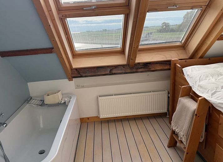 Sonniger Aussenbereich mit bunten Sitzgelegenheiten im Huisje in Bruinisse, Schouwen-Duiveland.