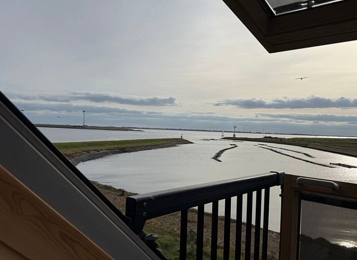 Gemuetlicher Innenraum mit Esstisch und Buecherregalen im Cottage in Bruinisse, Zeeland.