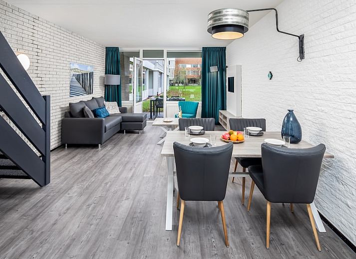 Gemuetliches Wohnzimmer der Ferienwohnung Comfort 4B in Bruinisse, Schouwen-Duiveland, mit moderner Einrichtung und Blick auf die gruene Umgebung.