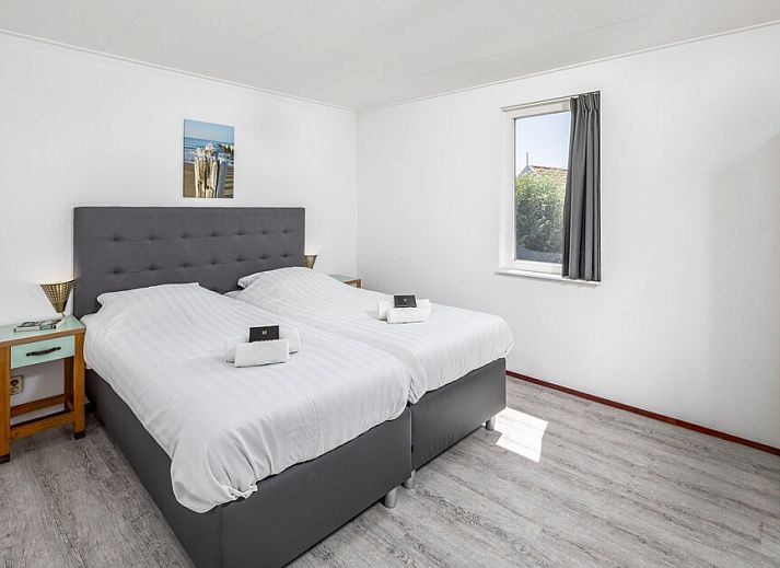 Ruime woonkamer van Buitenhuis Comfort 12, een vakantiehuis in Bruinisse, Schouwen-Duiveland, Zeeland, met comfortabele zithoek en uitzicht op de tuin.