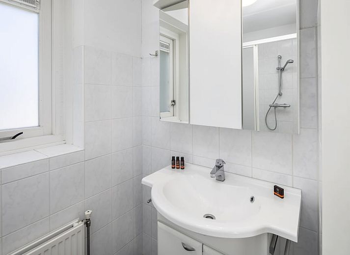 Ruime woonkamer van Buitenhuis Comfort 12, een vakantiehuis in Bruinisse, Schouwen-Duiveland, Zeeland, met comfortabele zithoek en uitzicht op de tuin.