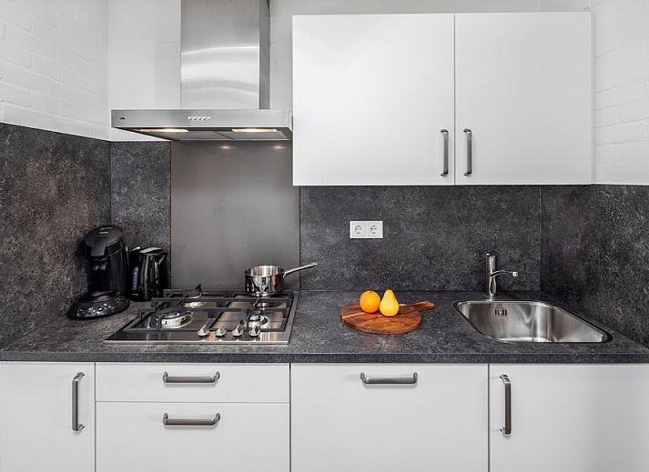 Modernes Wohnzimmer im Apartment Comfort 2B, Bruinisse, mit stilvollem Dekor und offener Kueche, ideal fuer einen entspannten Aufenthalt in Zeeland.