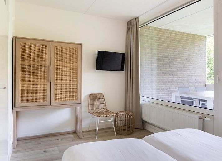 Stijlvolle woonkamer van Appartement Luxe 4B in Bruinisse, Schouwen-Duiveland, Zeeland met modern interieur en uitzicht op groene omgeving.