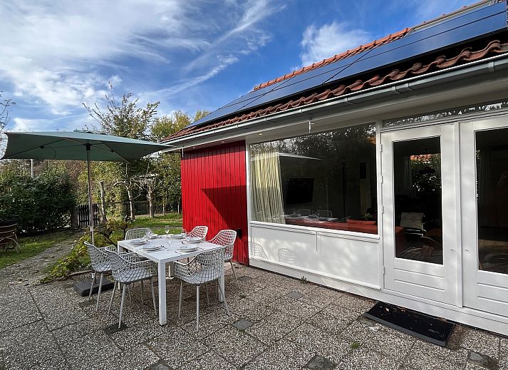 Gezellige binnenruimte van Vakantiewoning Het Ongerepte 21 'Kaatje Mossel' in Renesse, Zeeland, met eetgedeelte en uitzicht op de tuin.