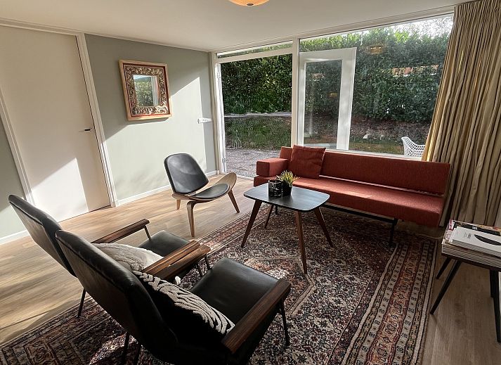 Gezellige binnenruimte van Vakantiewoning Het Ongerepte 21 'Kaatje Mossel' in Renesse, Zeeland, met eetgedeelte en uitzicht op de tuin.