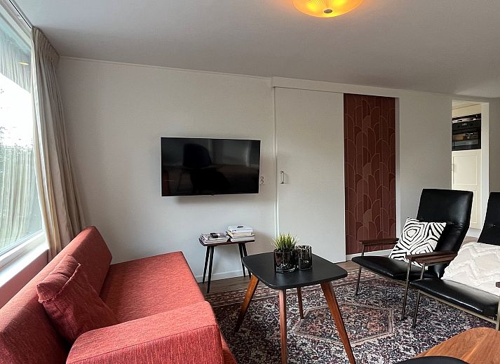 Gezellige binnenruimte van Vakantiewoning Het Ongerepte 21 'Kaatje Mossel' in Renesse, Zeeland, met eetgedeelte en uitzicht op de tuin.