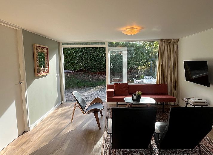 Gezellige binnenruimte van Vakantiewoning Het Ongerepte 21 'Kaatje Mossel' in Renesse, Zeeland, met eetgedeelte en uitzicht op de tuin.