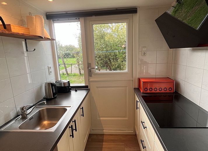 Vakantiewoning Het Ongerepte 21 'Kaatje Mossel' in Renesse, Zeeland, met charmante rode gevel en rustige omgeving.