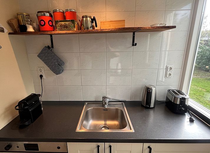 Vakantiewoning Het Ongerepte 21 'Kaatje Mossel' in Renesse, Zeeland, met charmante rode gevel en rustige omgeving.