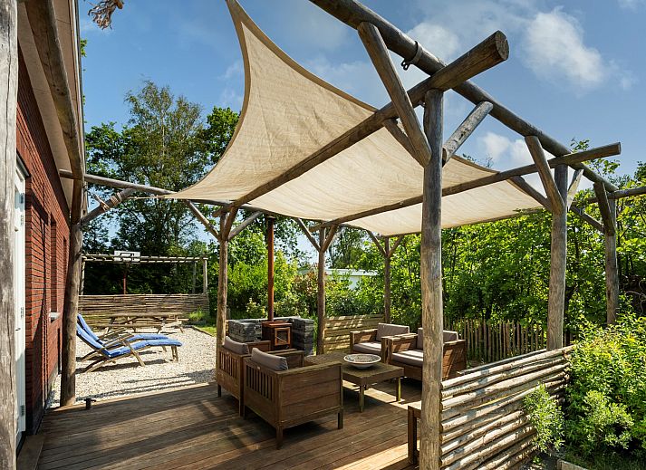 Ferienhaus De Zuidhoek 6 in Renesse, ein charmantes Ferienhaus mit einem sonnigen Garten und Liegestuehlen.