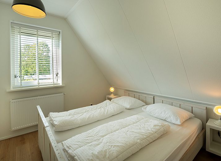 Ferienhaus De Zuidhoek 6 in Renesse, eingezaeunt mit Holzzaun und gruener Umgebung.