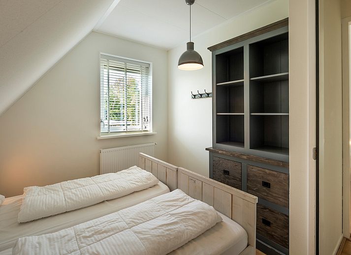 Ferienhaus De Zuidhoek 6 in Renesse, eingezaeunt mit Holzzaun und gruener Umgebung.