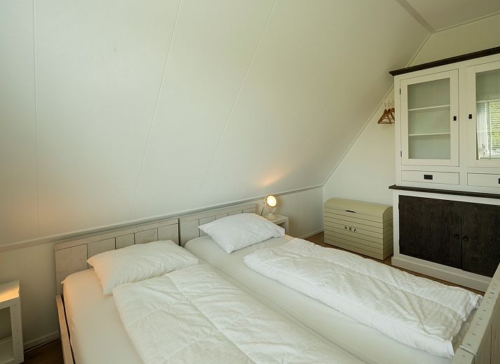 Ferienhaus De Zuidhoek 6 in Renesse, eingezaeunt mit Holzzaun und gruener Umgebung.