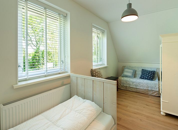 Ferienhaus De Zuidhoek 6 in Renesse, eingezaeunt mit Holzzaun und gruener Umgebung.