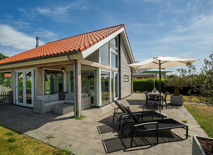 Seitenansicht des Ferienhauses Zonnedorp 8, De Zeehond in Renesse, Zeeland mit einem gepflegten Garten.