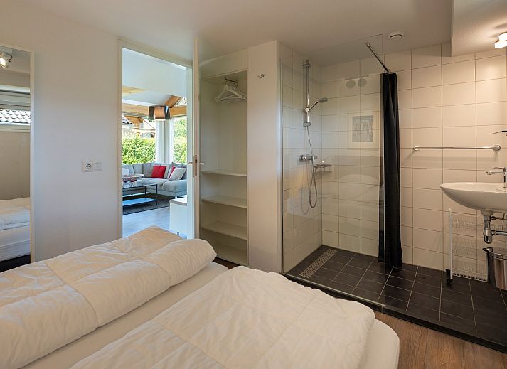 Gemuetlicher Aussenbereich des Ferienhauses Zonnedorp 8, De Zeehond in Renesse, Zeeland mit Sonnenschirmen.