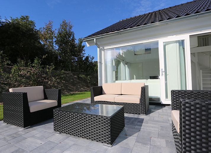 Das Ferienhaus Zonnedorp 4, Villa Jula in Renesse bietet eine sonnige Terrasse mit modernen Moebeln in gruener Umgebung.