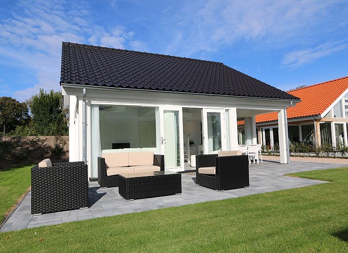Das Ferienhaus Zonnedorp 4, Villa Jula in Renesse bietet eine sonnige Terrasse mit modernen Moebeln in gruener Umgebung.