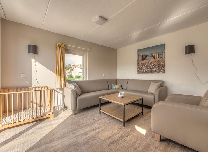 Front of Comfort 6K bungalow in Renesse, Schouwen-Duiveland, Zeeland, surrounded by green nature and rustic architecture.