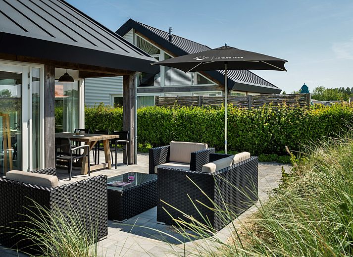 Vakantiehuis Zonnedorp 15 'Stuurboord' in Renesse, Zeeland, met een uitnodigende tuin en moderne architectuur omgeven door natuur.