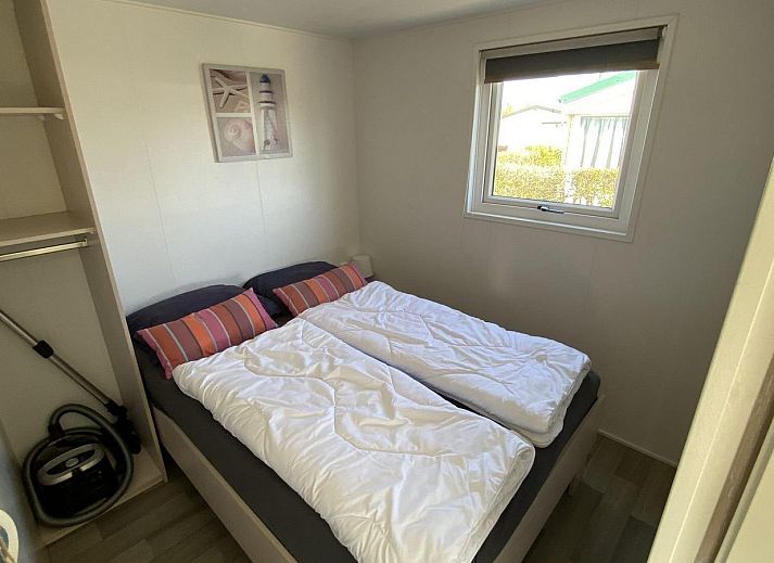 Sonnenterrasse des VZ466 Chalet Duif 258 in Renesse, komplett mit Esstisch und Sonnenschirm in Schouwen-Duiveland, Zeeland.