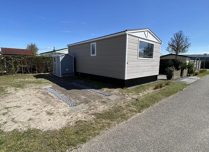 Sonnenterrasse des VZ466 Chalet Duif 258 in Renesse, komplett mit Esstisch und Sonnenschirm in Schouwen-Duiveland, Zeeland.