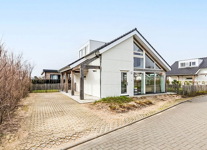 Manicured garden with deck chairs at Holiday home Duinzicht Renesse, ideal for relaxation in Zeeland.
