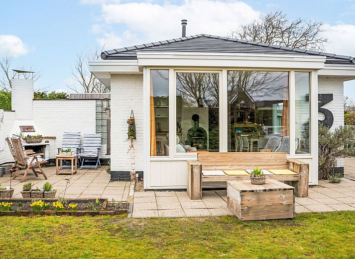 Vacation home Horizon by the Sea in Renesse, cozy terrace with wooden furniture and lots of greenery.