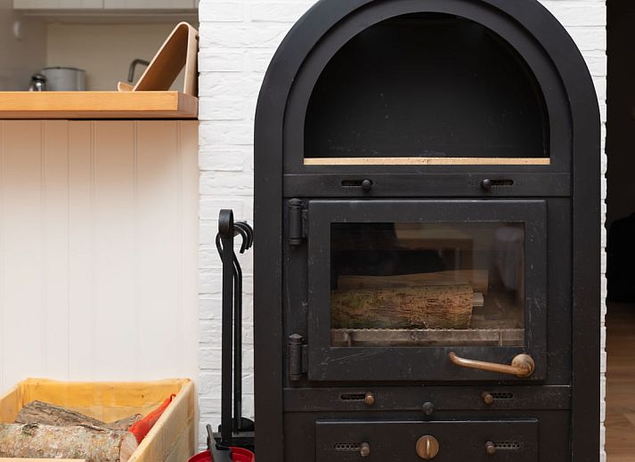 Sunny terrace with deck chairs and fireplace at Holiday home Horizon by the Sea, Renesse, ideal for relaxation.