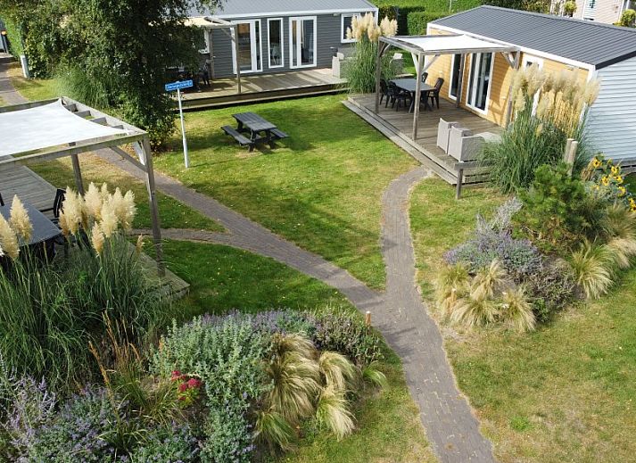 Verseputshofje chalet in Renesse, Zeeland met veranda en groene tuin, ideaal voor een ontspannen vakantie op Schouwen-Duiveland.