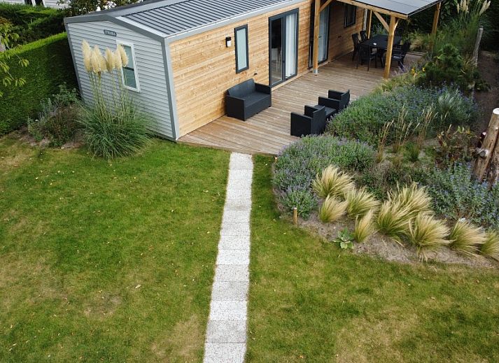 Verseputshofje chalet in Renesse, Zeeland met veranda en groene tuin, ideaal voor een ontspannen vakantie op Schouwen-Duiveland.