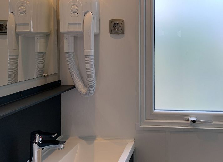 Verseputshofje chalet in Renesse, Zeeland met veranda en groene tuin, ideaal voor een ontspannen vakantie op Schouwen-Duiveland.