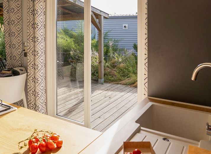 Verseputshofje chalet in Renesse, Schouwen-Duiveland, Zeeland met een uitnodigende veranda en weelderige tuinomgeving.