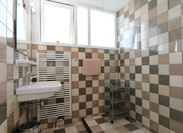 Cozy sitting area in vacation home Zonnedorp 14 Mon Repos in Renesse with green sofa and cushions