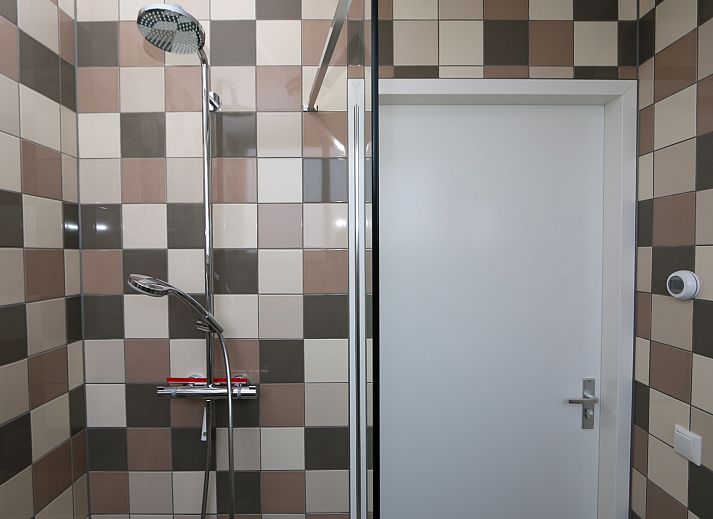 Cozy sitting area in vacation home Zonnedorp 14 Mon Repos in Renesse with green sofa and cushions