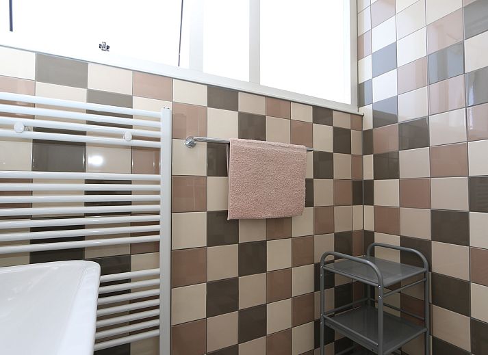 Cozy sitting area in vacation home Zonnedorp 14 Mon Repos in Renesse with green sofa and cushions