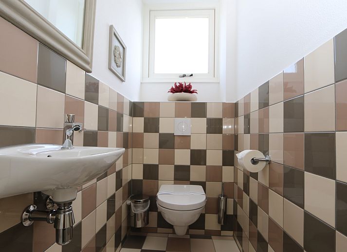 Cozy sitting area in vacation home Zonnedorp 14 Mon Repos in Renesse with green sofa and cushions