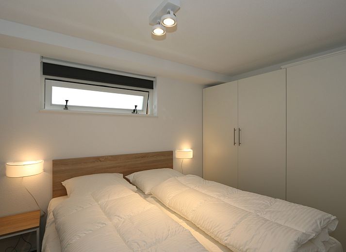 Rueckseite des Ferienhauses Zonnedorp 18, Duinhuis 18 in Renesse, Zeeland mit grosser Terrasse und Rasen.