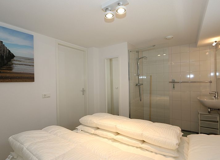 Rueckseite des Ferienhauses Zonnedorp 18, Duinhuis 18 in Renesse, Zeeland mit grosser Terrasse und Rasen.