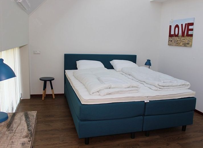 Stilvolles Esszimmer in einem Ferienhaus im Strandpark De Zeeuwse Kust, Renesse, mit Holztisch und Lederstuehlen.