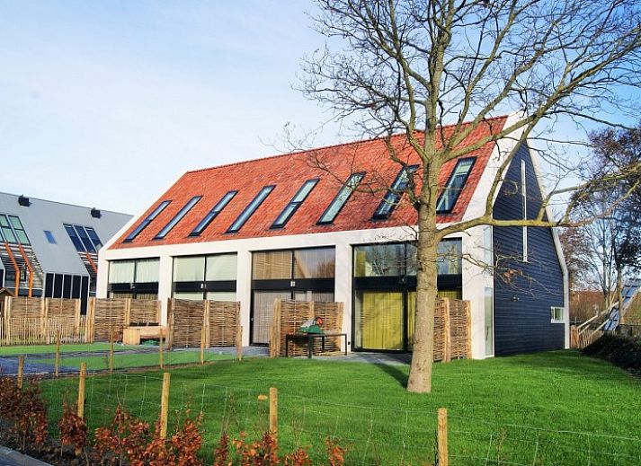 Stilvolles Esszimmer in einem Ferienhaus im Strandpark De Zeeuwse Kust, Renesse, mit Holztisch und Lederstuehlen.