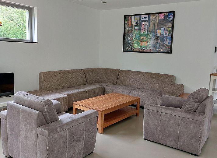 Terrace of Family House Bremweg 22 in Renesse, with wooden seating and surrounded by green nature.