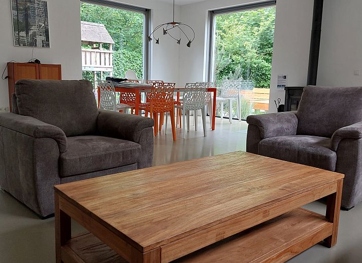 Terrace of Family House Bremweg 22 in Renesse, with wooden seating and surrounded by green nature.