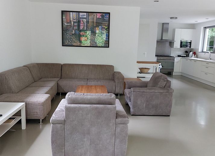 Terrace of Family House Bremweg 22 in Renesse, with wooden seating and surrounded by green nature.