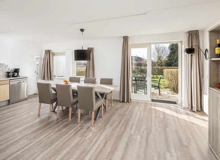 Lichte en ruime eetkamer van SD6 Comfort bungalow in Renesse, Schouwen-Duiveland, Zeeland met uitzicht op de tuin.